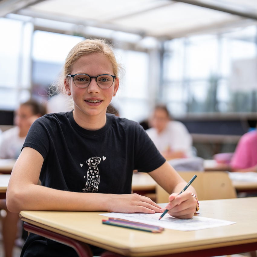 Meisje zittend op een bank voor kluisjes