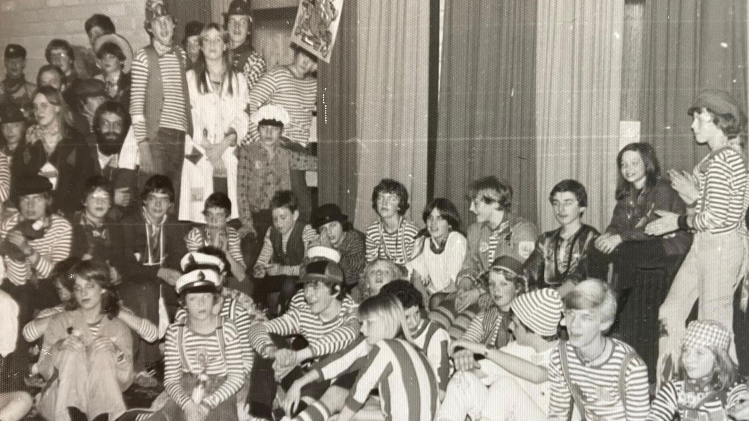 Docent leidt groep lachende studenten in klaslokaal