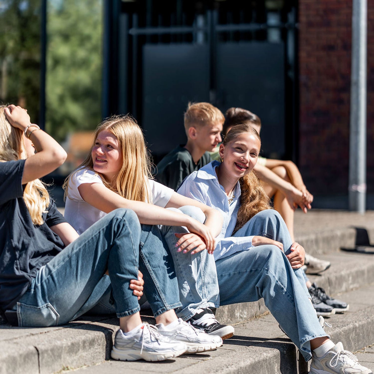 Meisje zittend op een bank voor kluisjes