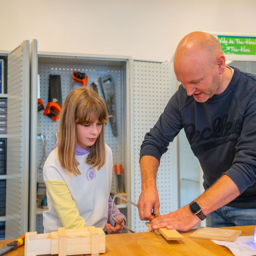 Docent leidt groep lachende studenten in klaslokaal