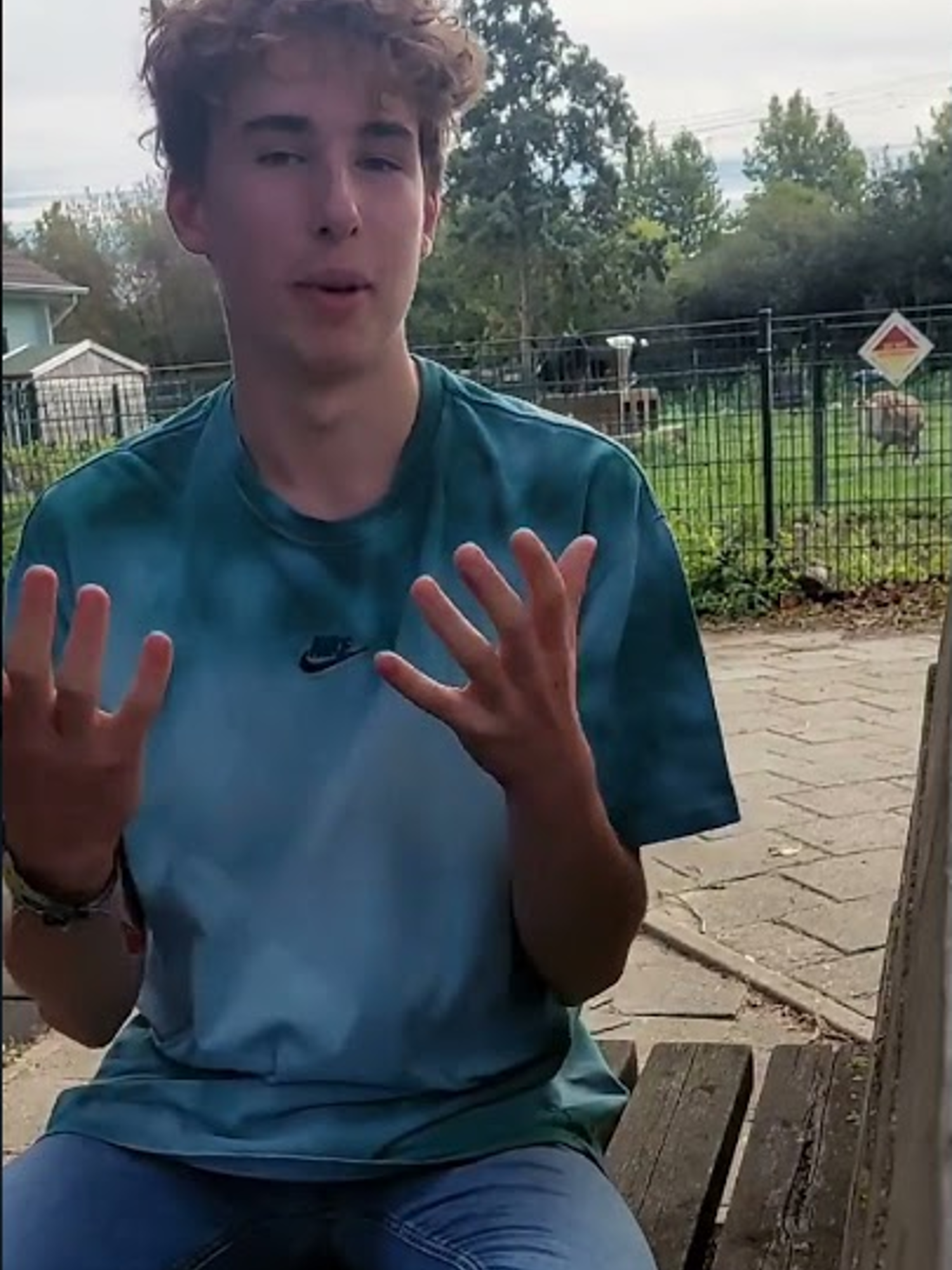 Een hoveniersstudent houdt lachend een vlag vast van Yuverta