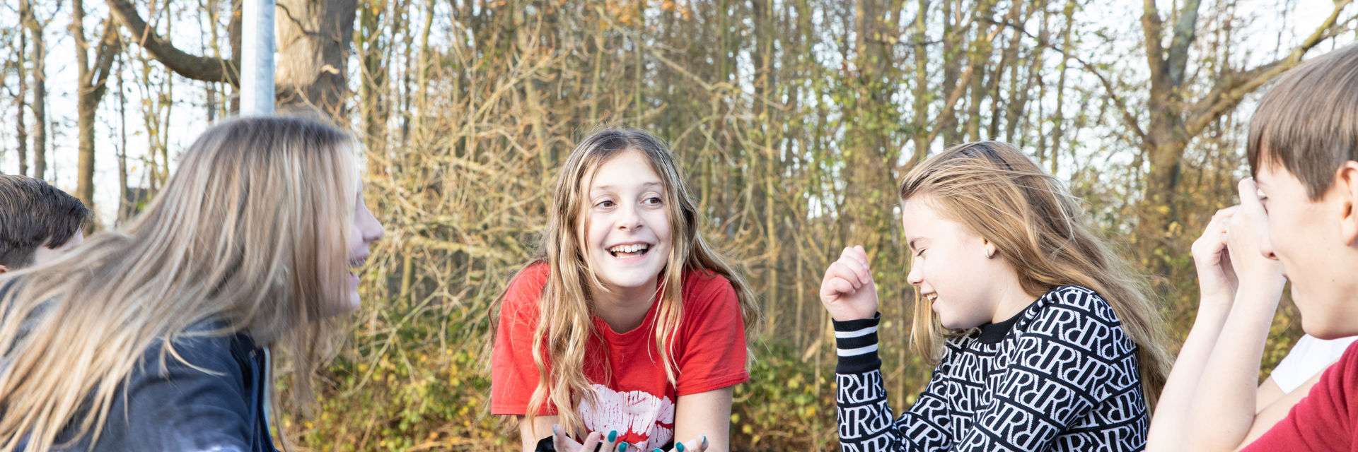 Lachende leerlingen aan een picknicktafel in de buitenlucht