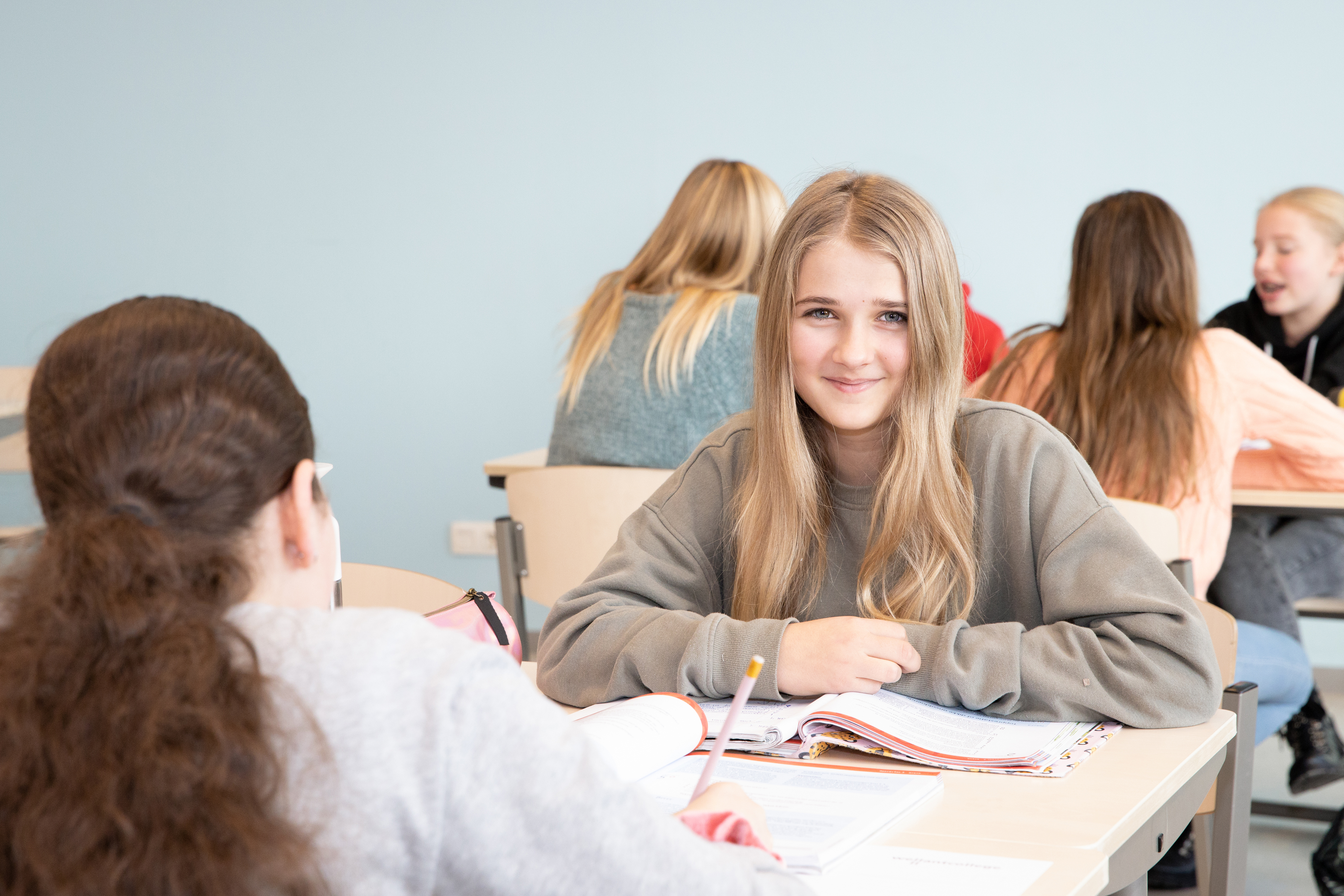 Meisje zittend op een bank voor kluisjes