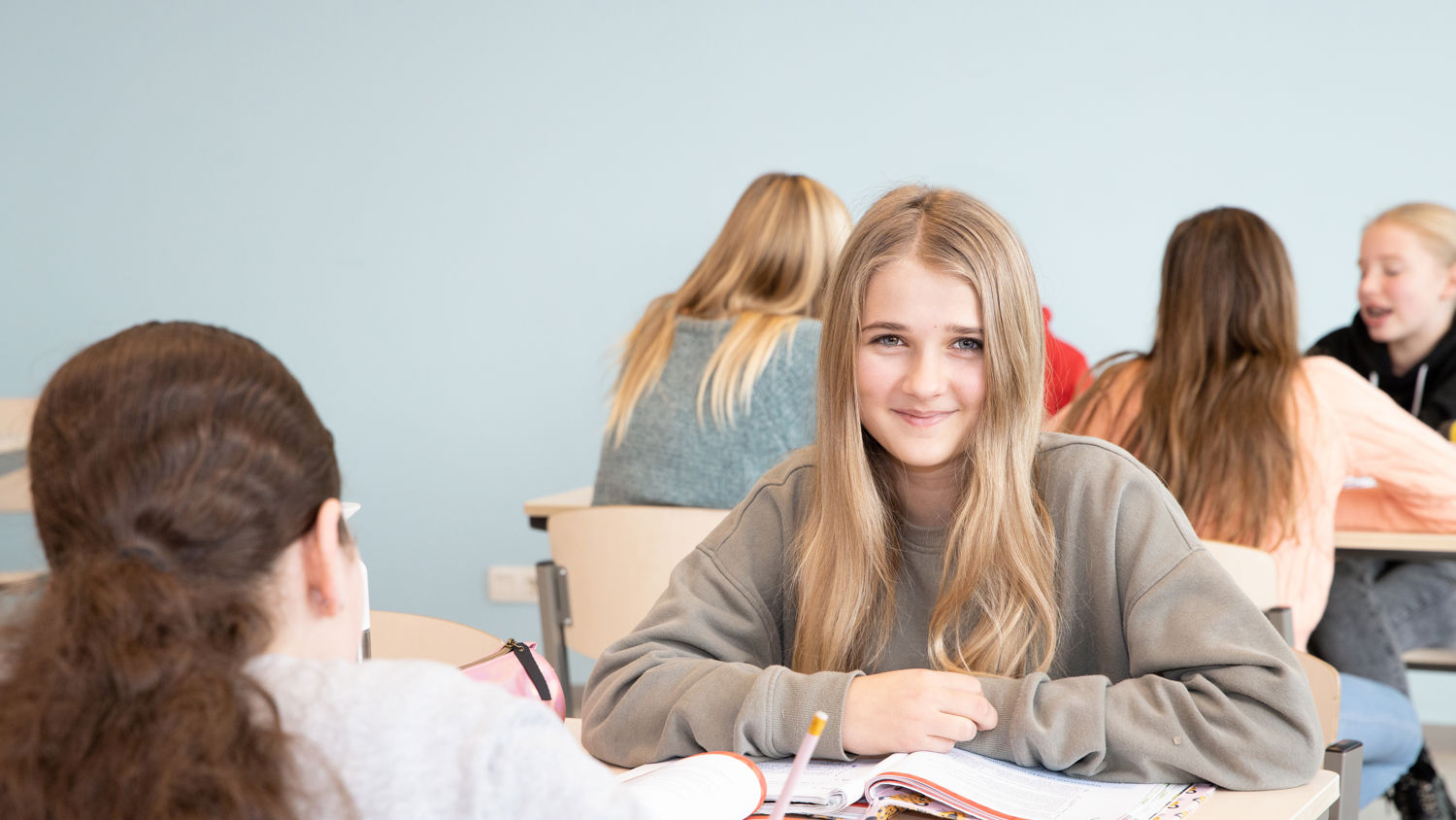 Meisje zittend op een bank voor kluisjes
