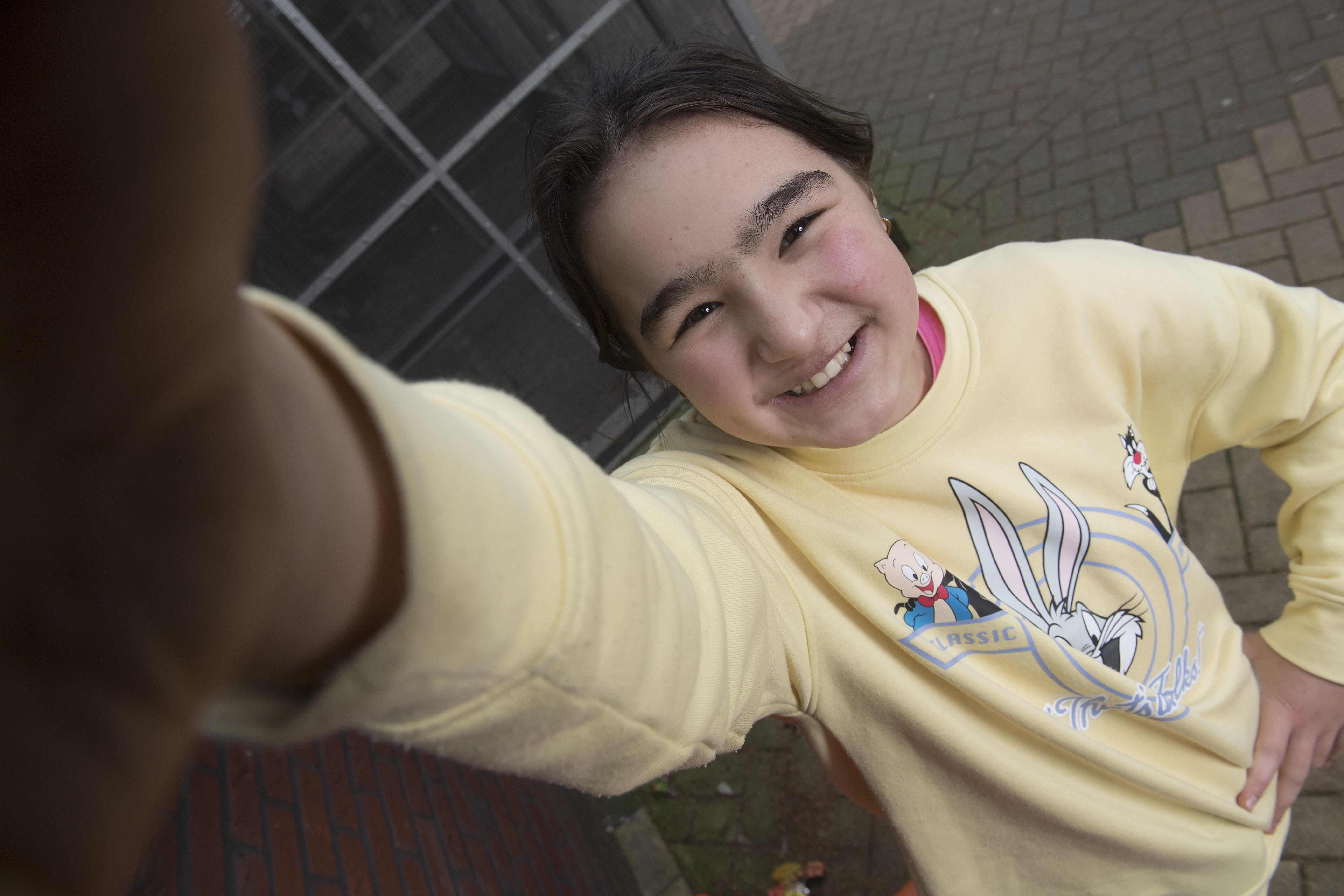 een leerling kijkt lachend naar de camera