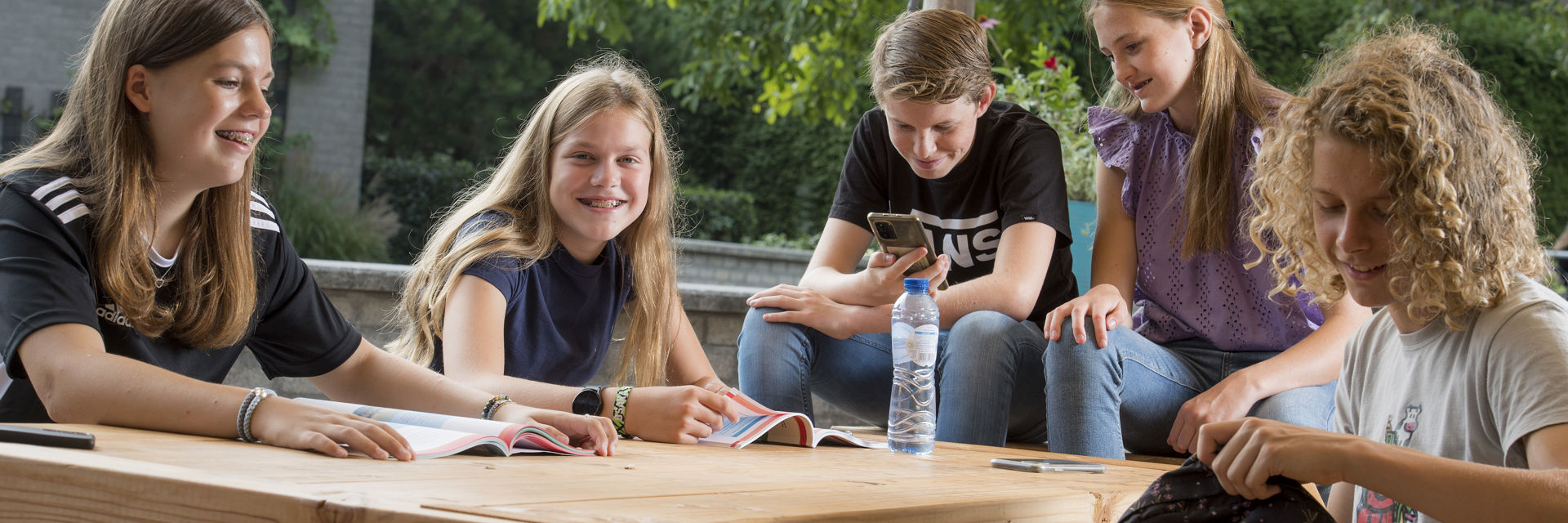 Een groep studenten zit samen buiten