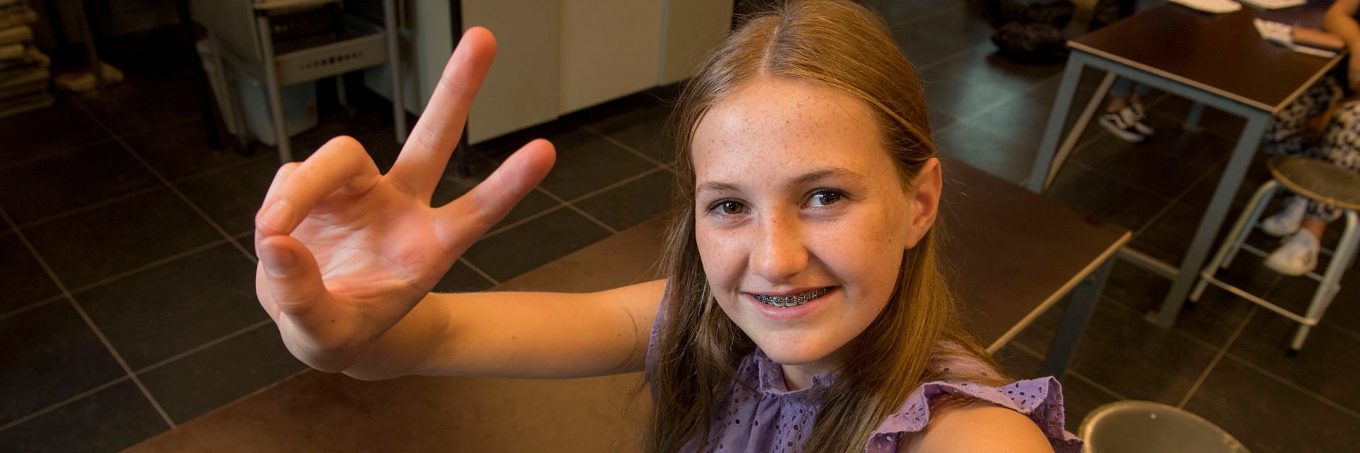 Een leerling houdt twee vingers omhoog