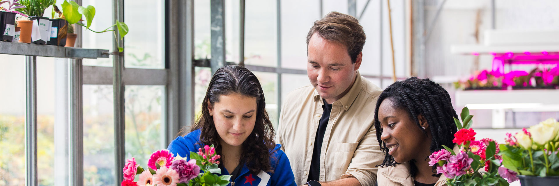 Een docent helpt met bloemschikken