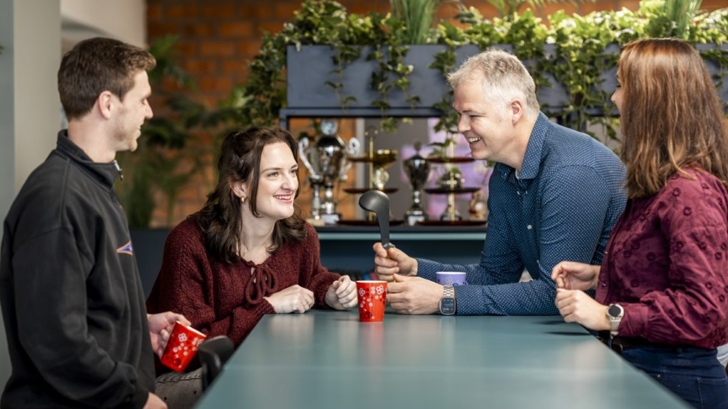 Docent leidt groep lachende studenten in klaslokaal