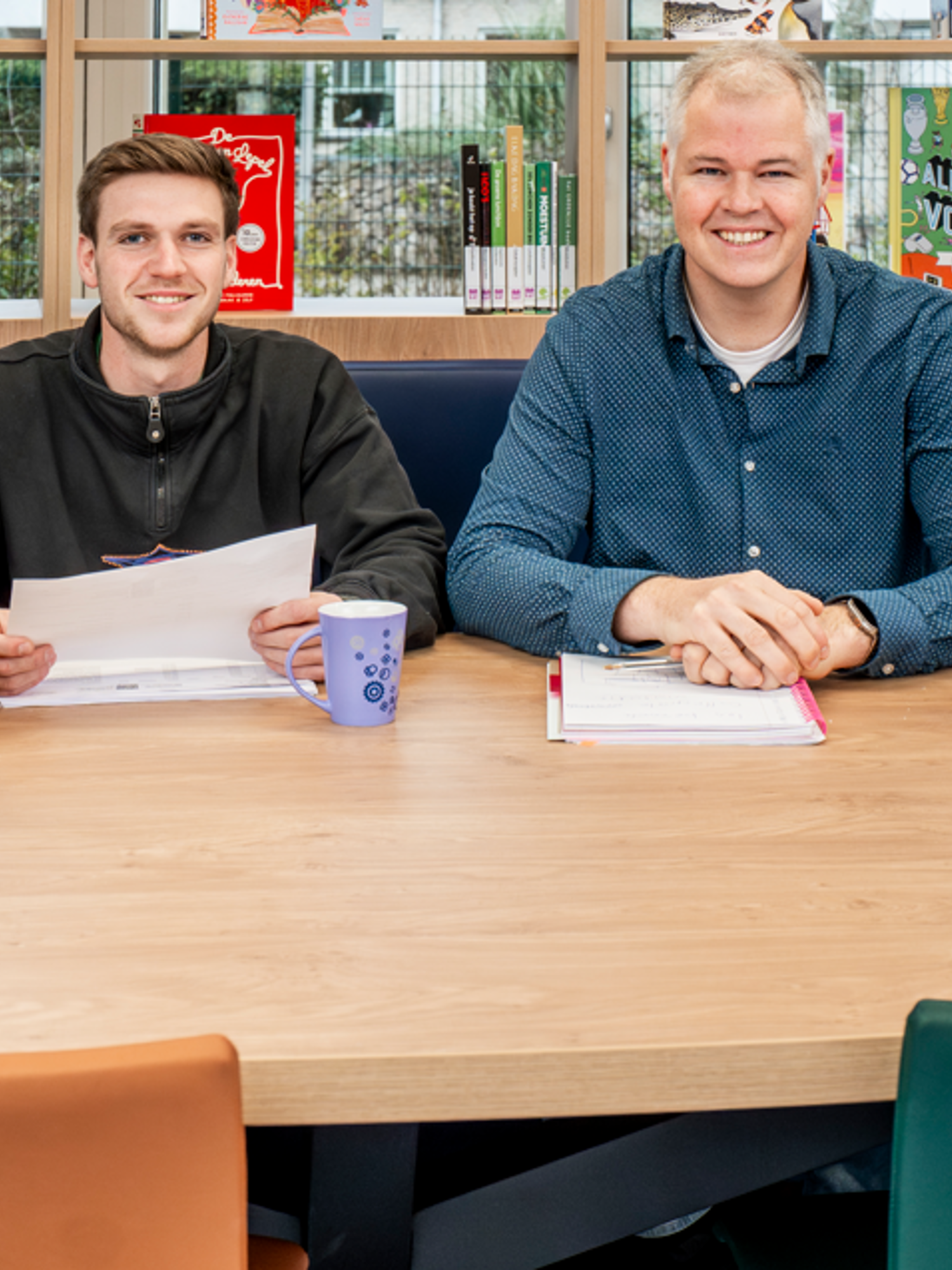 Docent leidt groep lachende studenten in klaslokaal