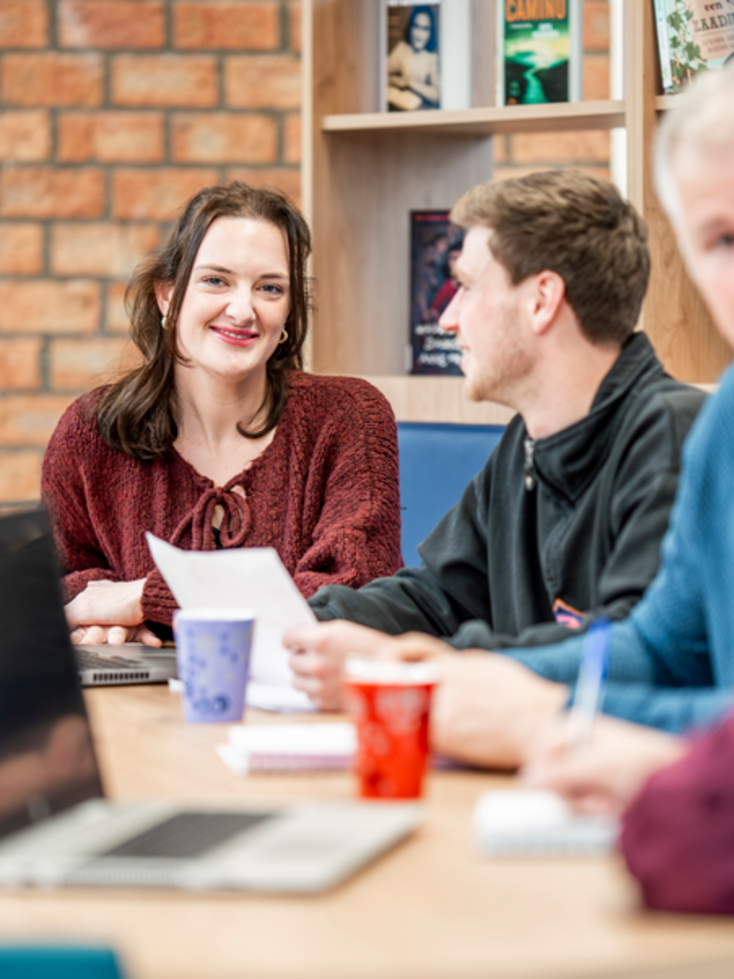 Docent leidt groep lachende studenten in klaslokaal