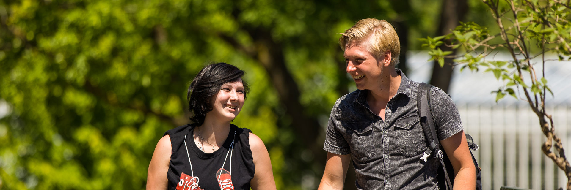 Twee leerlingen lopen samen in een groene omgeving