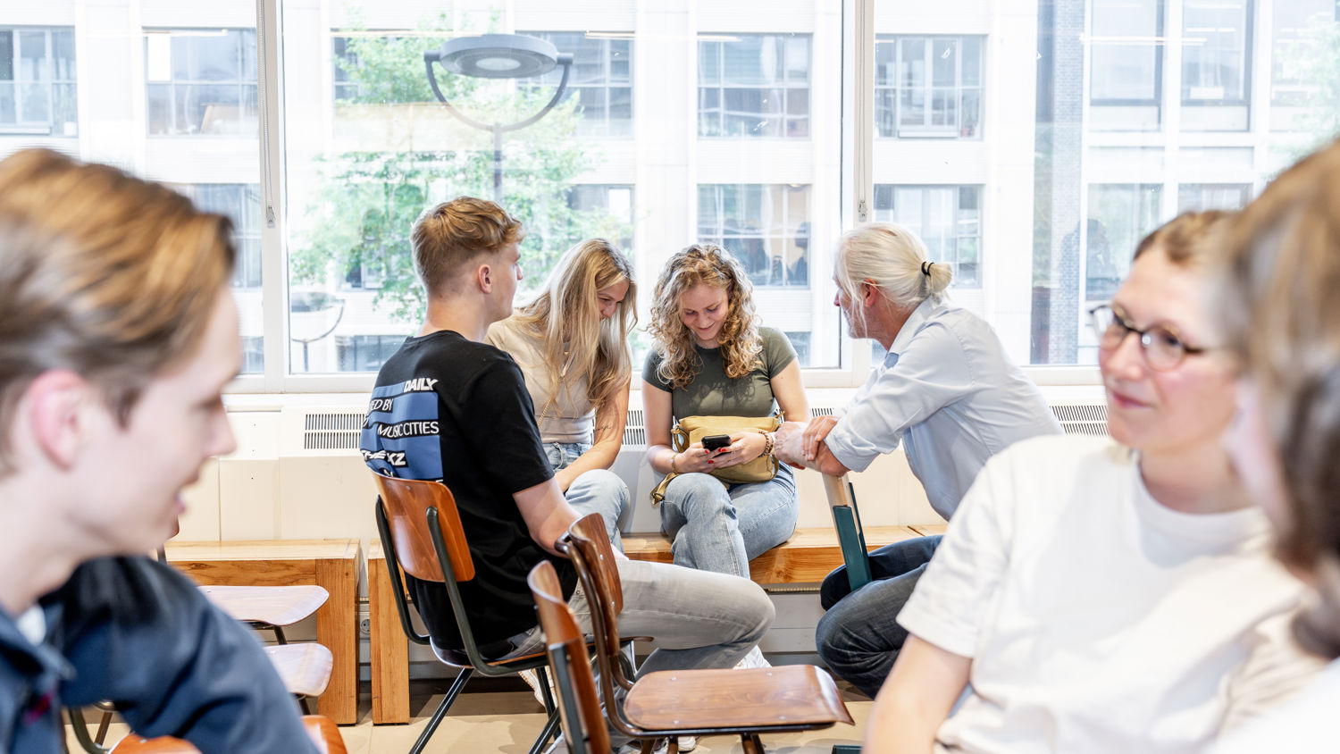 Meisje zittend op een bank voor kluisjes