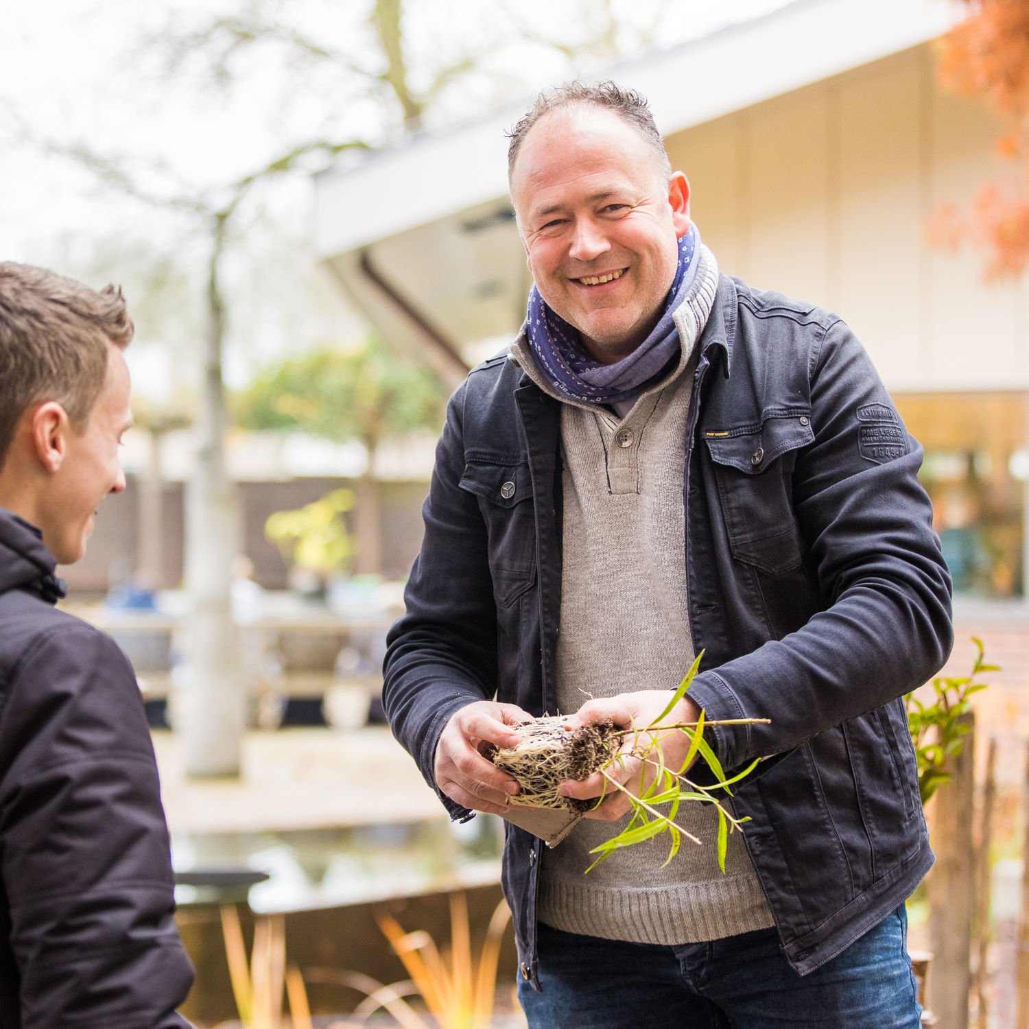 Docent leidt groep lachende studenten in klaslokaal