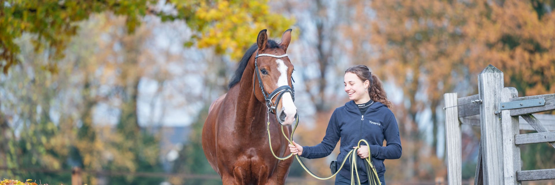 Studente loopt met een paard aan de hand buiten