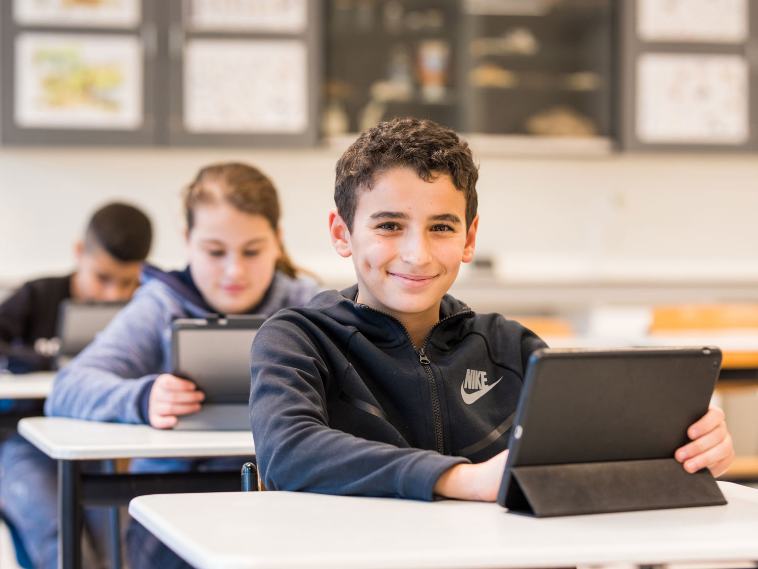 Meisje zittend op een bank voor kluisjes