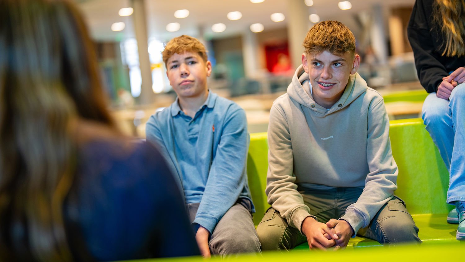 Meisje zittend op een bank voor kluisjes