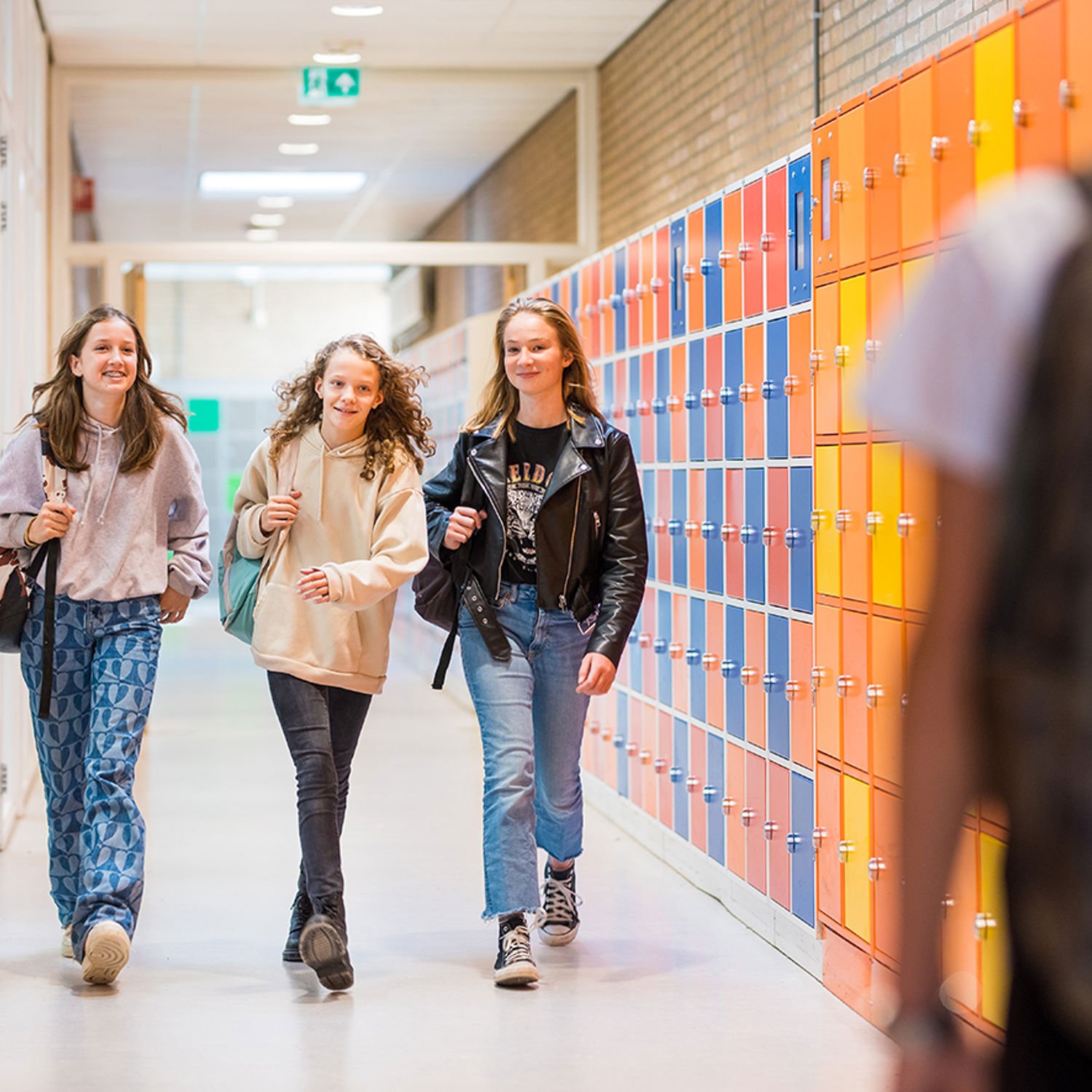 Meisje zittend op een bank voor kluisjes