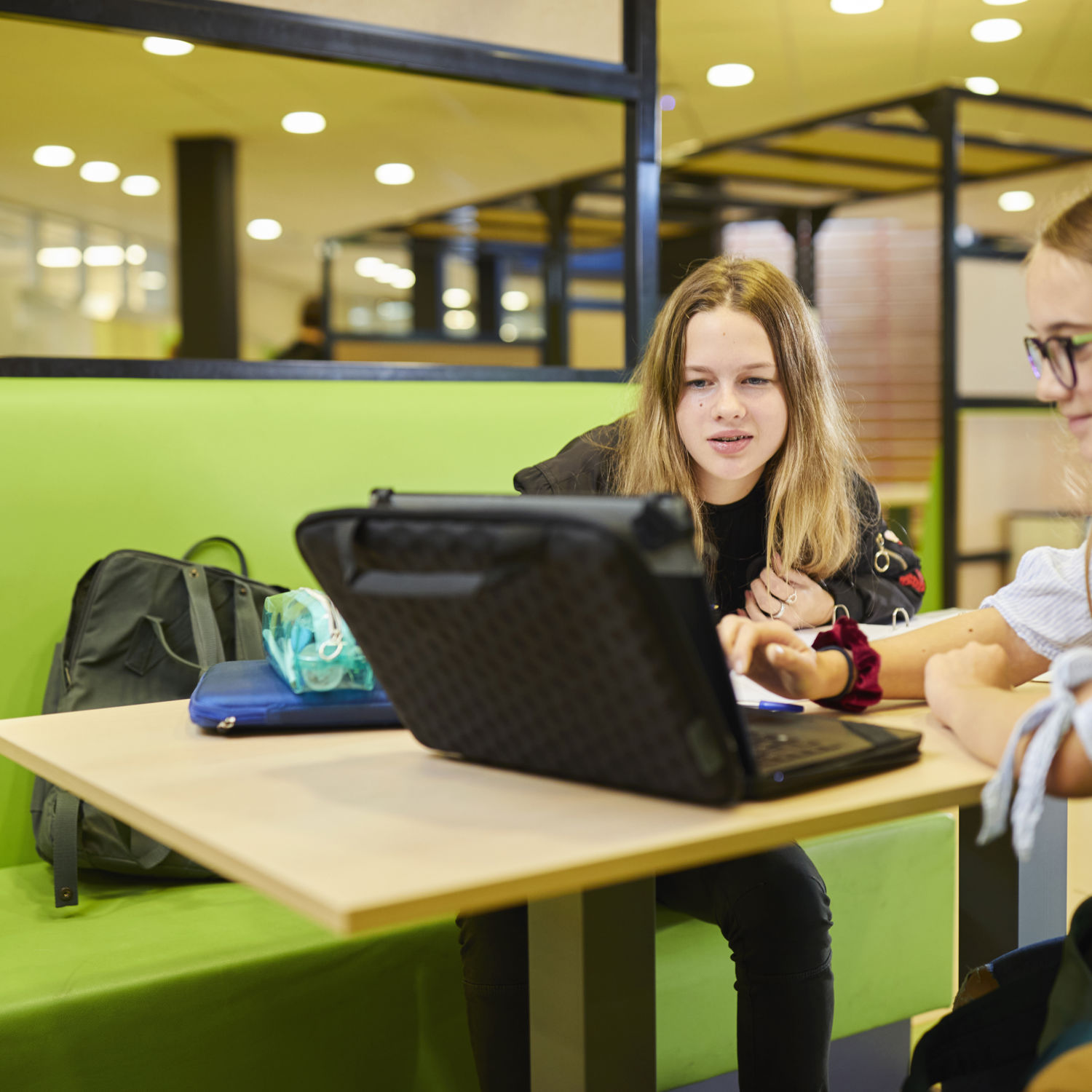 Meisje zittend op een bank voor kluisjes