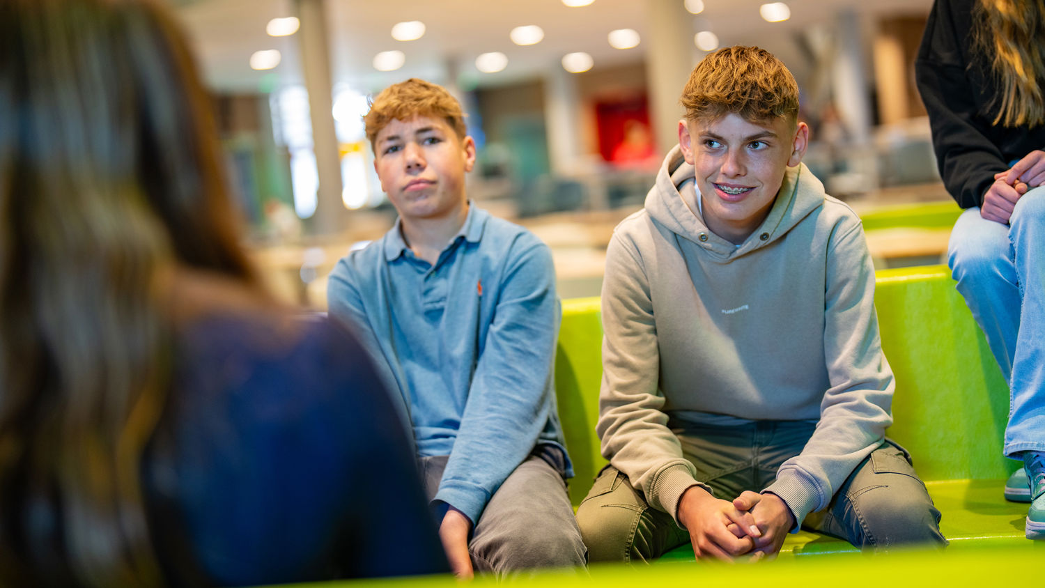Meisje zittend op een bank voor kluisjes
