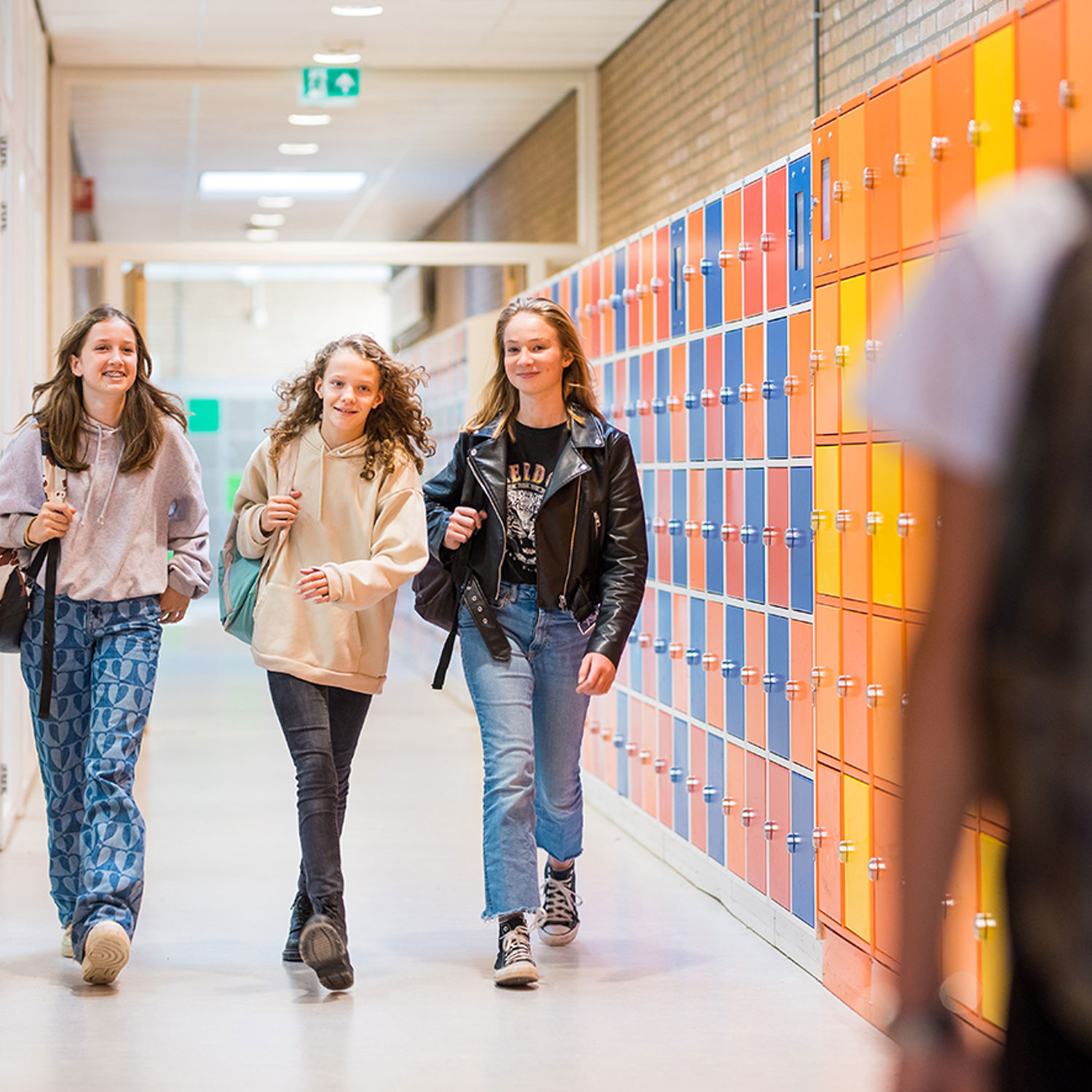 Meisje zittend op een bank voor kluisjes