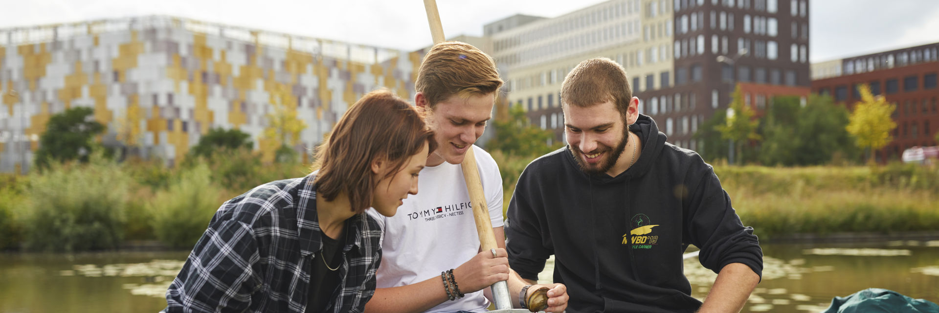 Drie studenten voeren wateronderzoek uit