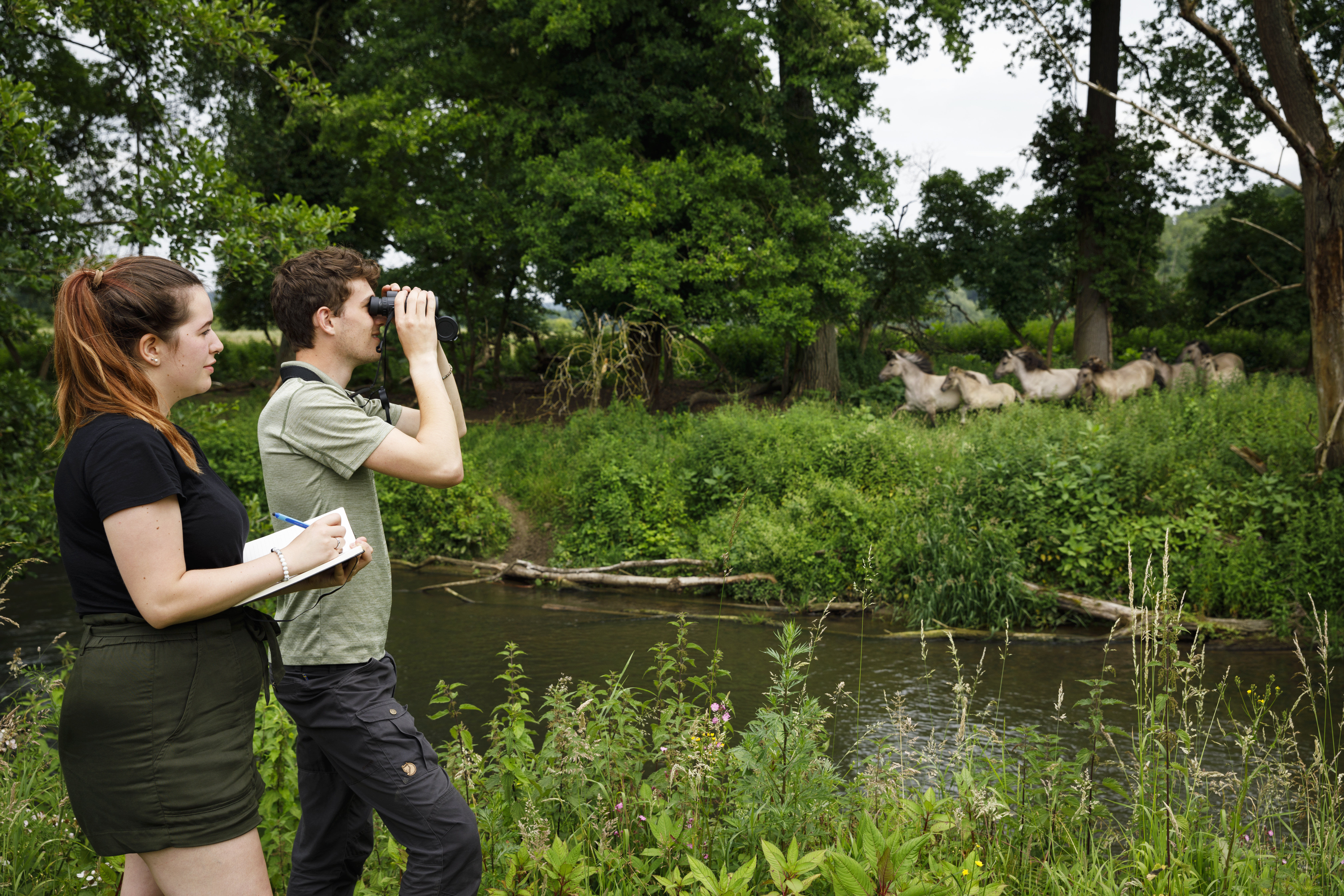 Docent leidt groep lachende studenten in klaslokaal