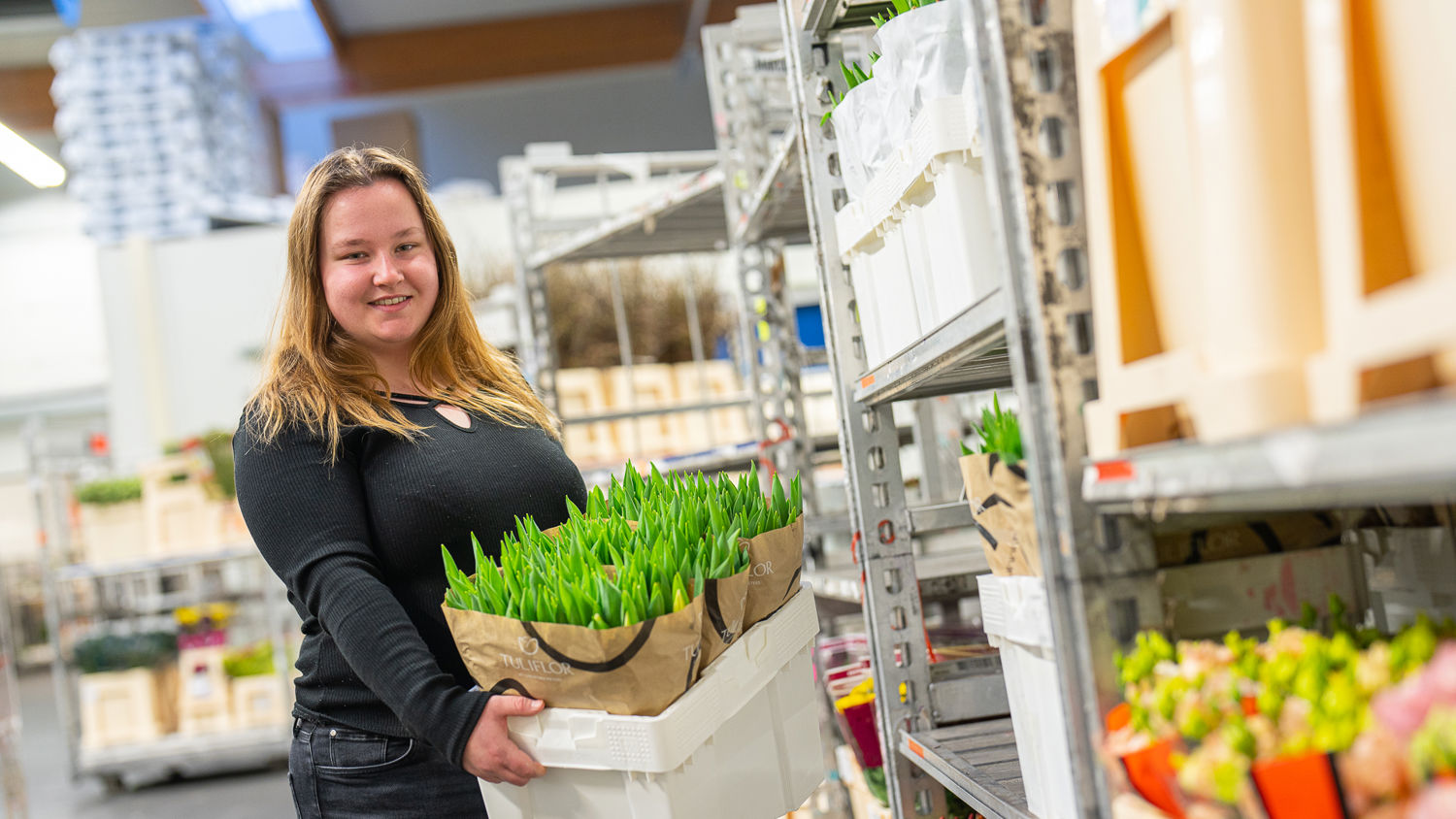Een student met planten in de hand