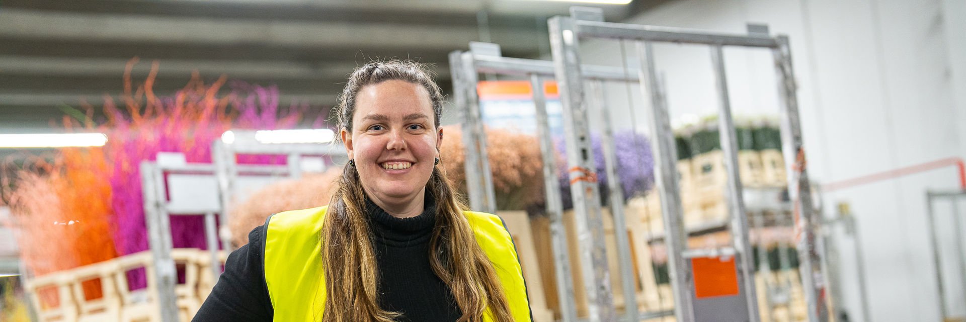 Een student poseert in een bloemenopslag