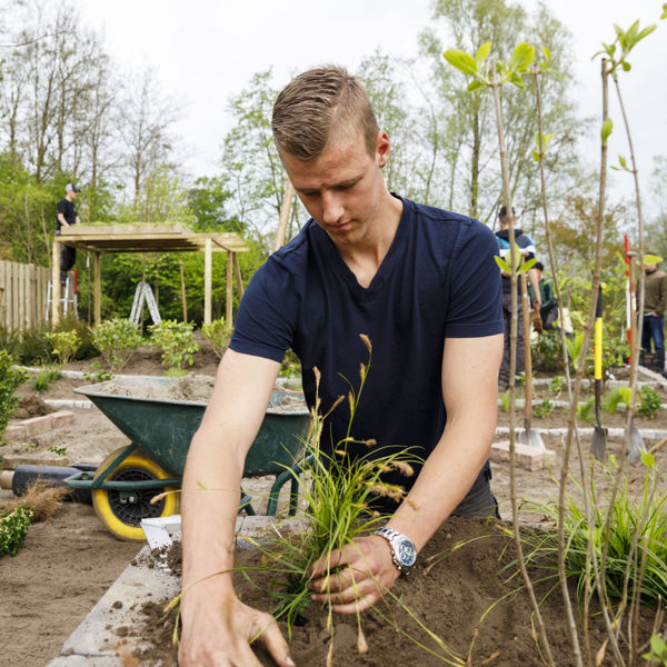 Een student met planten in de hand