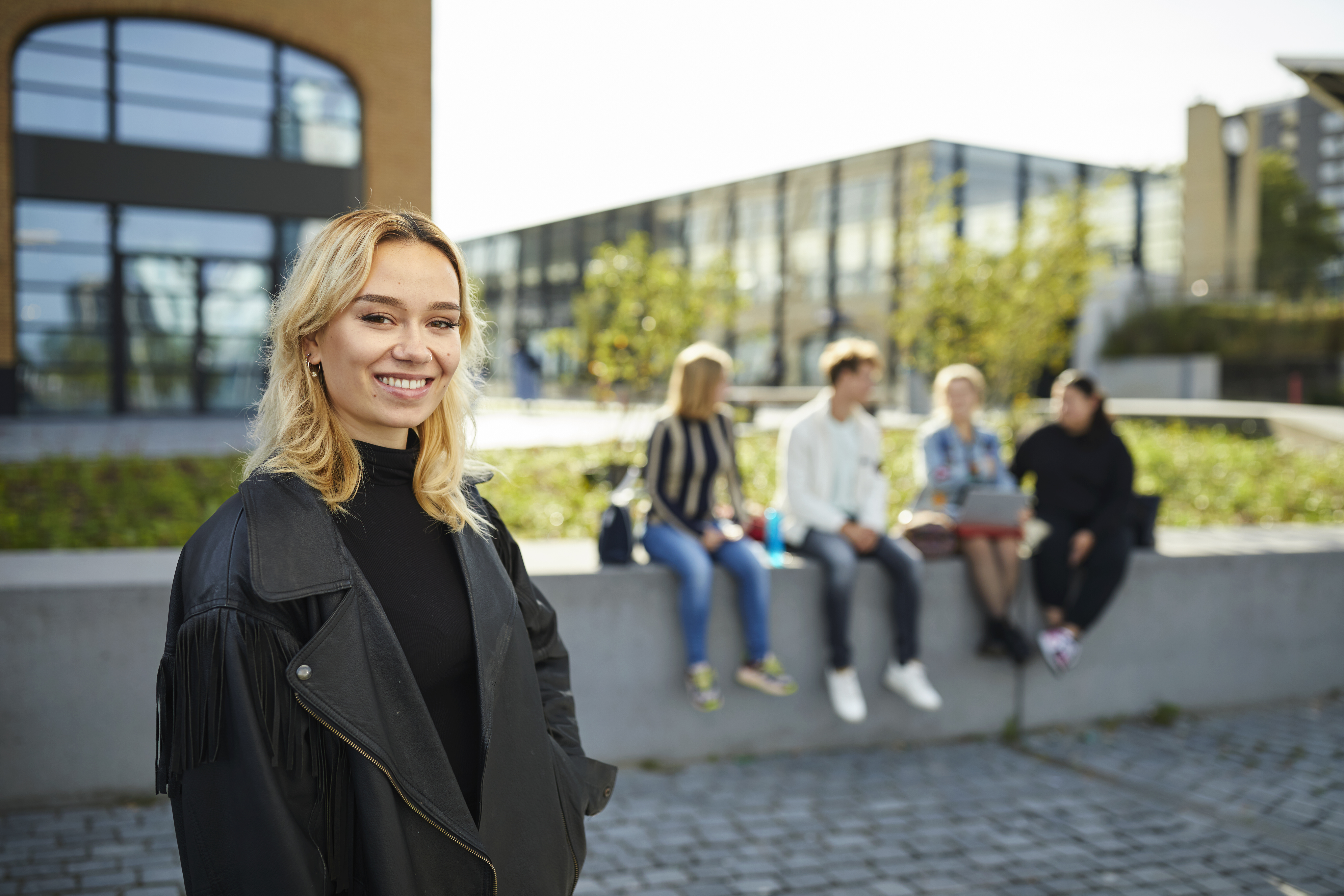 Docent leidt groep lachende studenten in klaslokaal