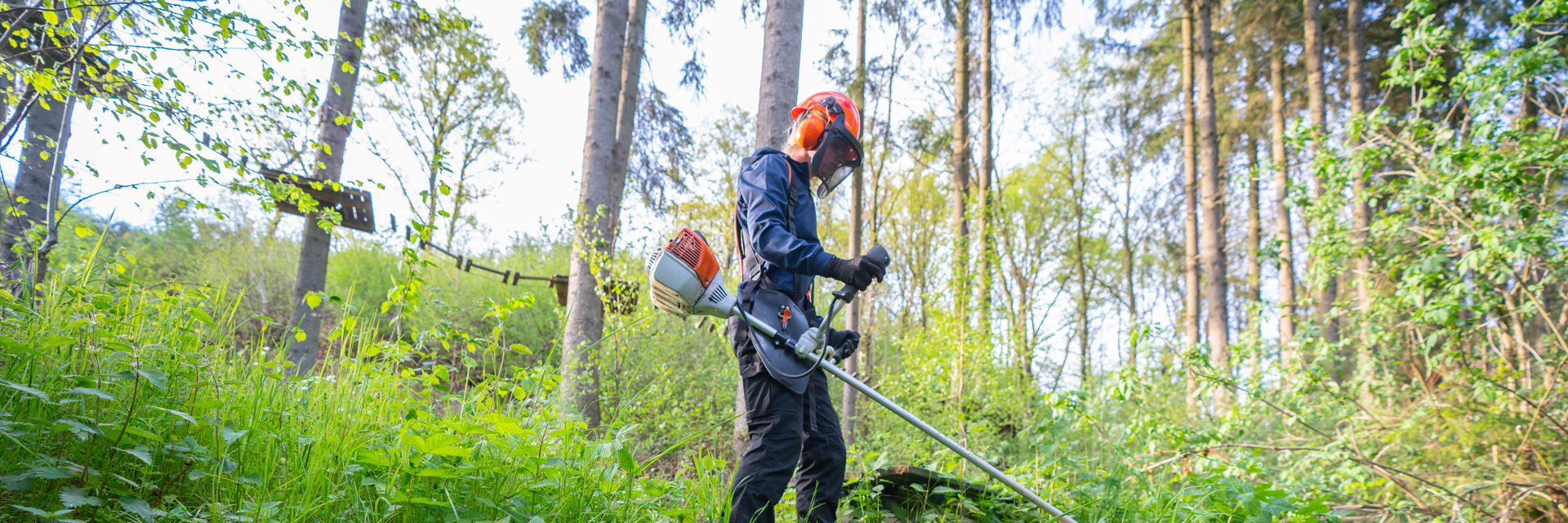 Student in het bos met bosmaaier