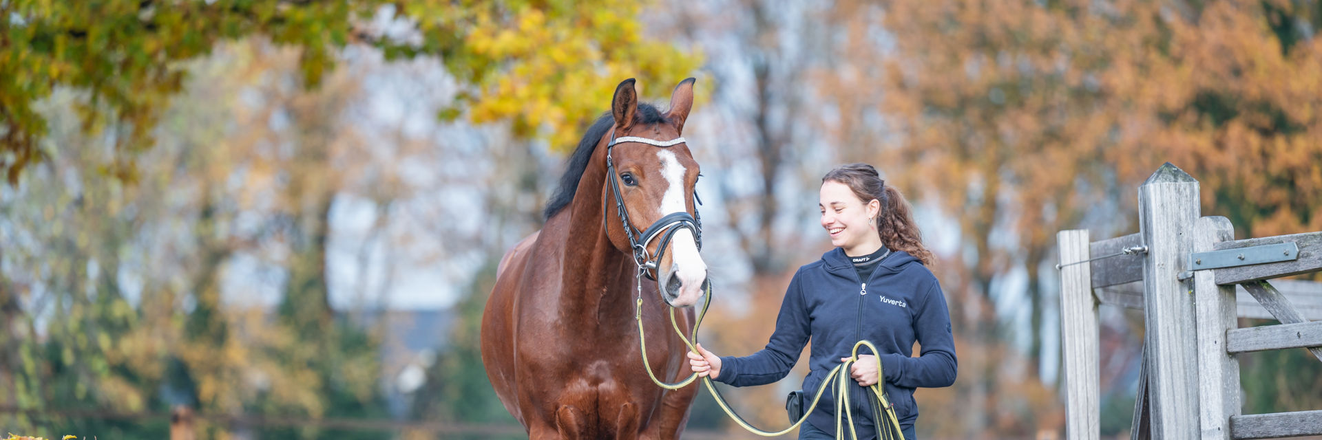 Een student loopt met een paard aan de hand