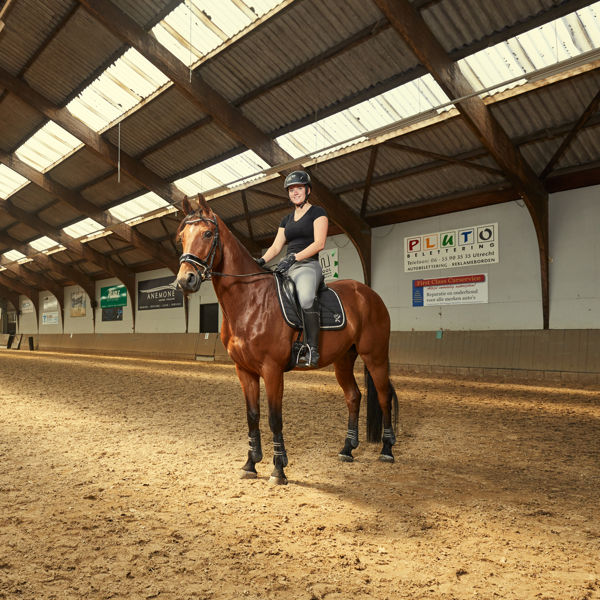 Een student rijdt lachend paard