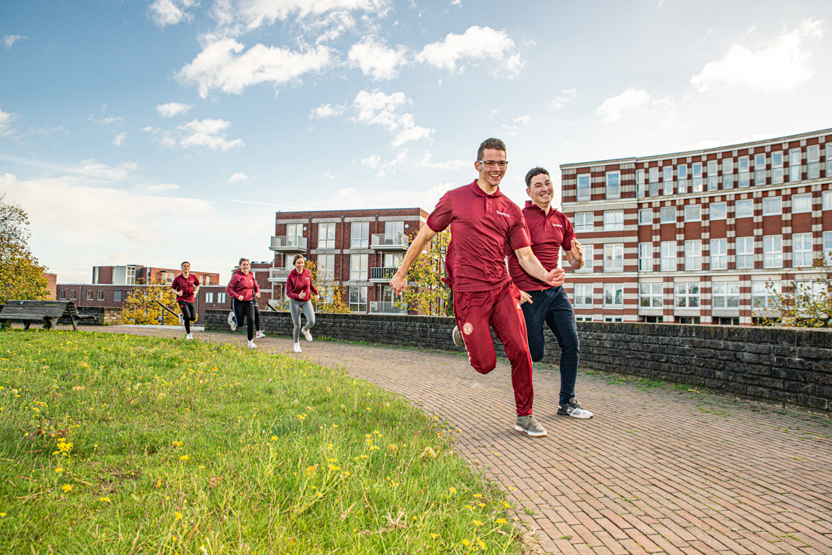 Docent leidt groep lachende studenten in klaslokaal