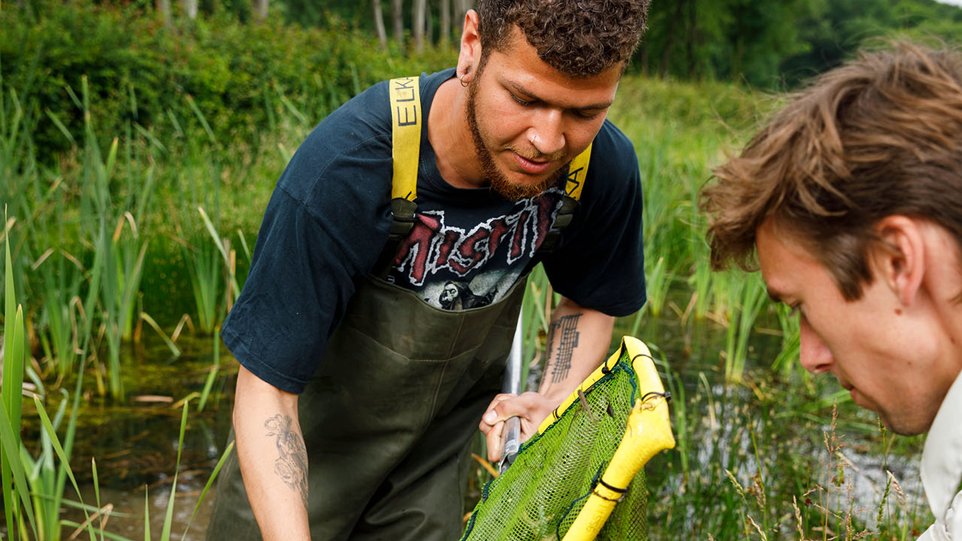 Docent leidt groep lachende studenten in klaslokaal