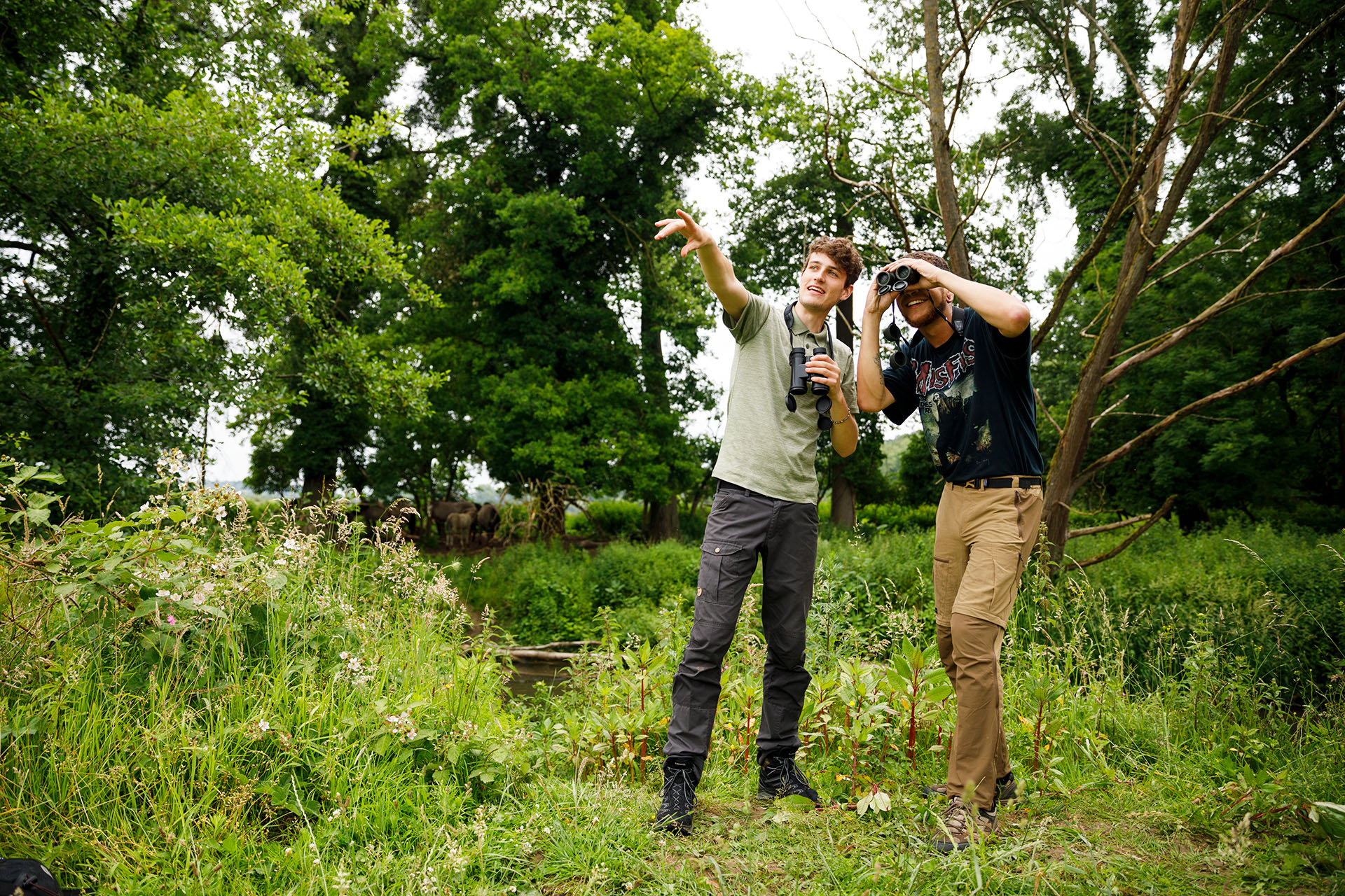 Twee studenten met verrekijkers in het bos