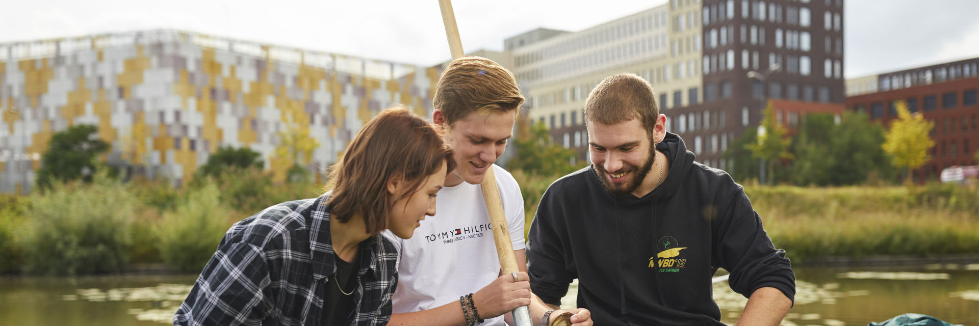 Drie studenten voeren wateronderzoek uit