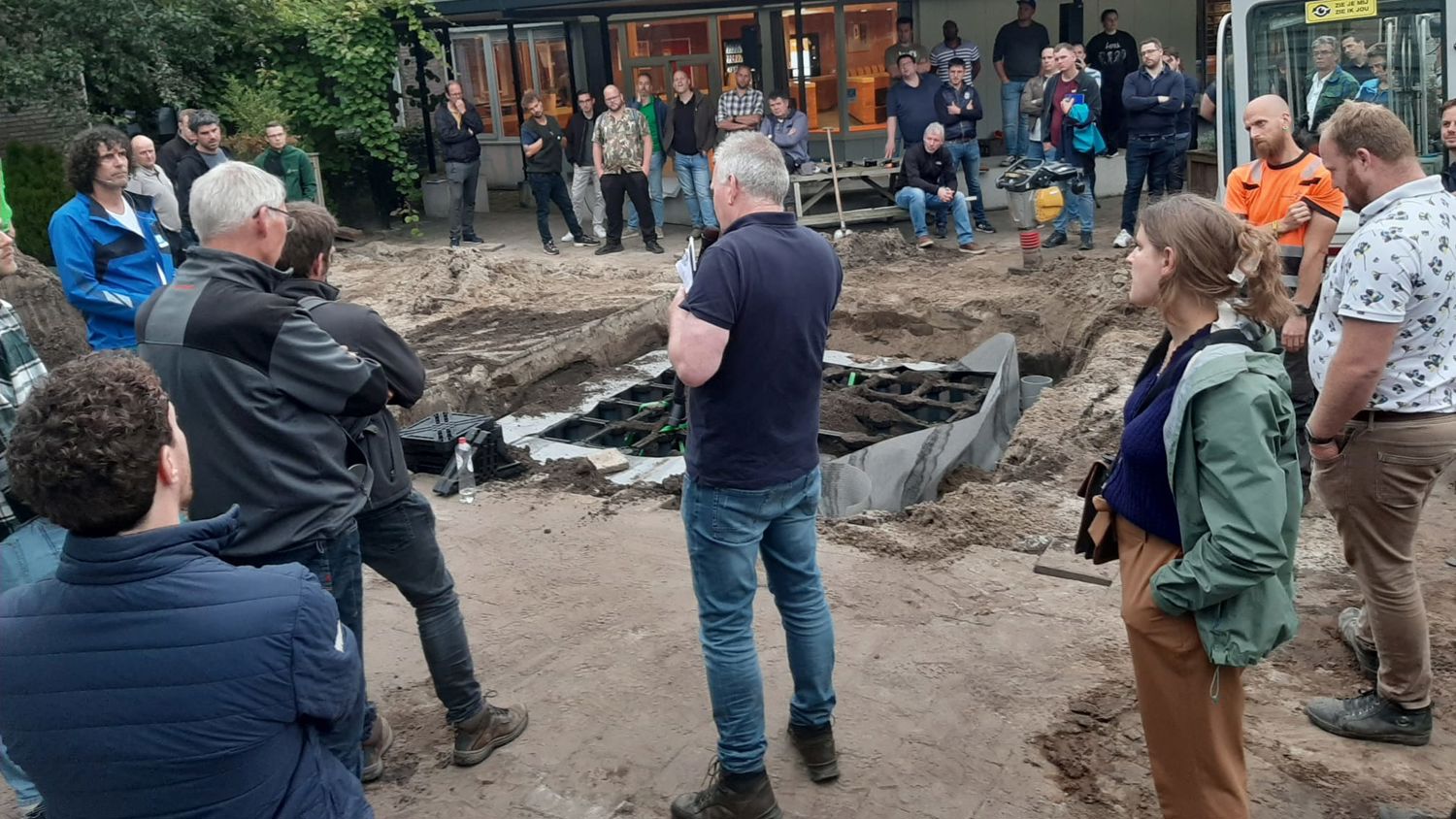 Docent leidt groep lachende studenten in klaslokaal
