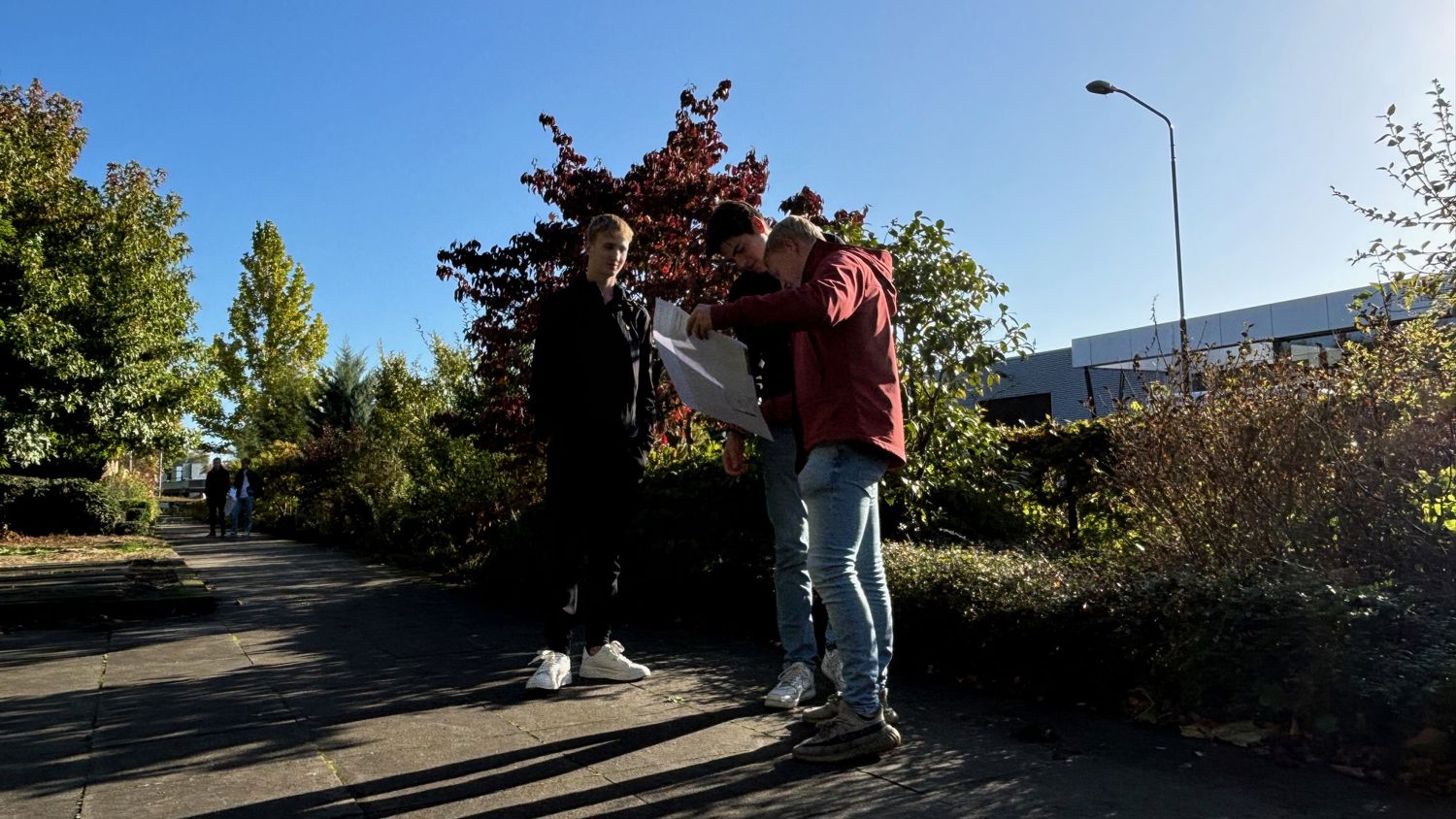 Docent leidt groep lachende studenten in klaslokaal