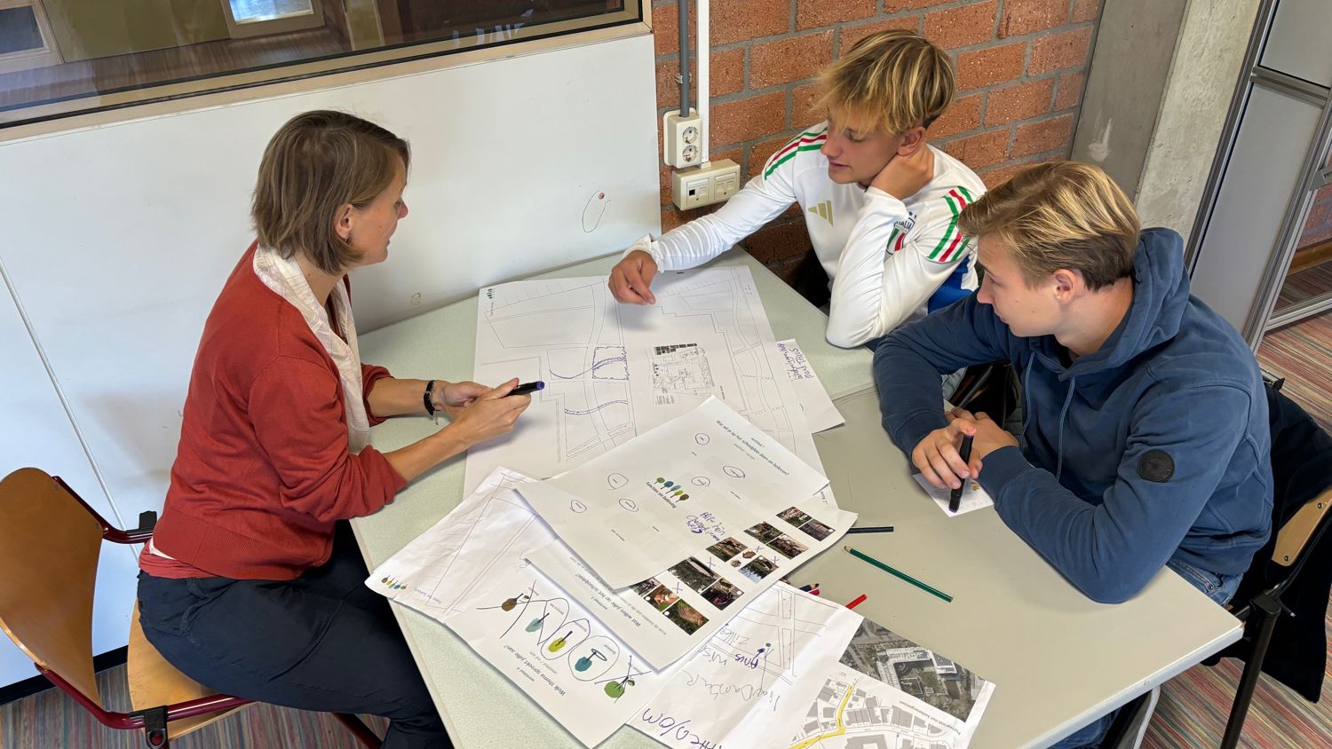 Docent leidt groep lachende studenten in klaslokaal