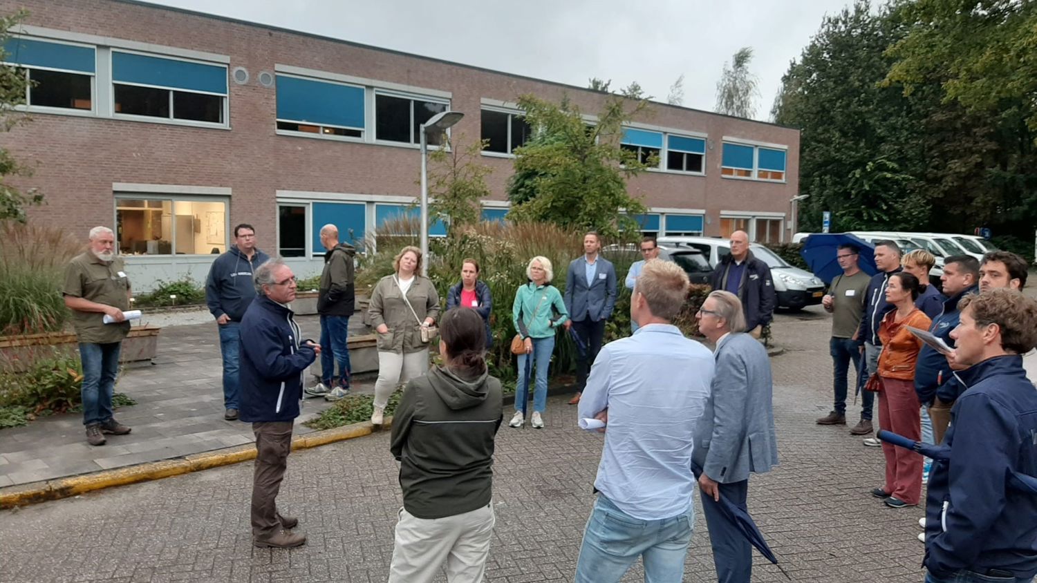 Docent leidt groep lachende studenten in klaslokaal
