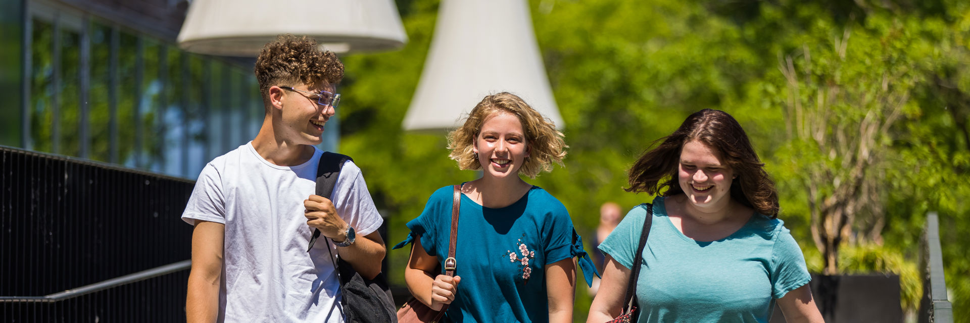 Drie studenten lopen samen buiten