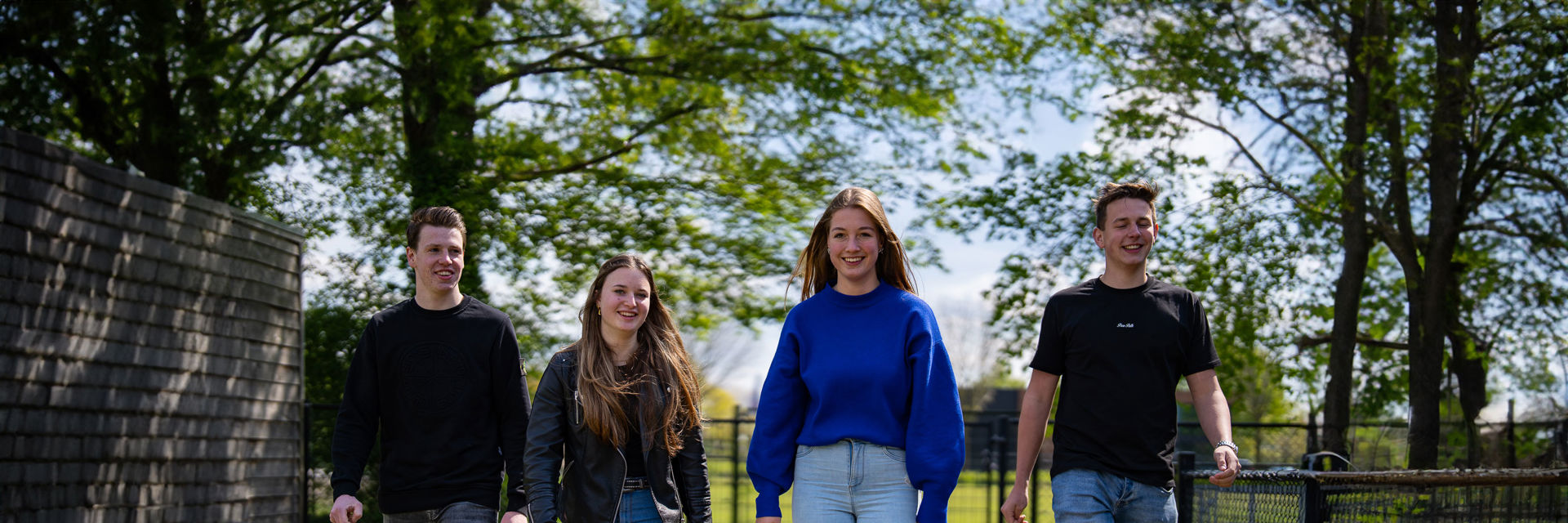 Vier leerlingen lopen over het buitenterrein
