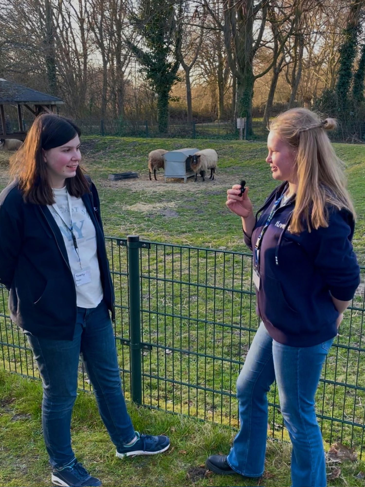 Een hoveniersstudent houdt lachend een vlag vast van Yuverta