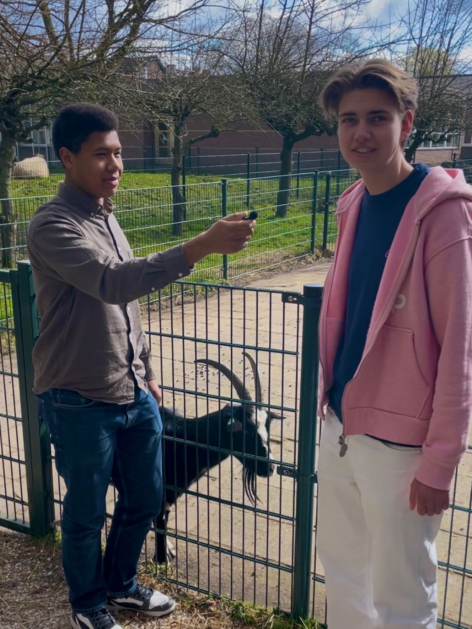 Een hoveniersstudent houdt lachend een vlag vast van Yuverta