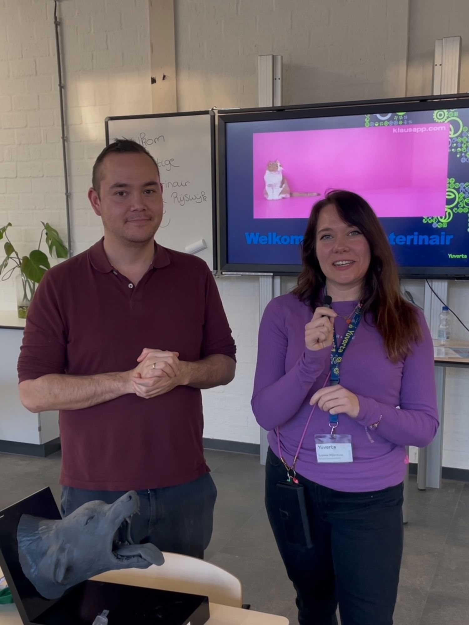 Een hoveniersstudent houdt lachend een vlag vast van Yuverta