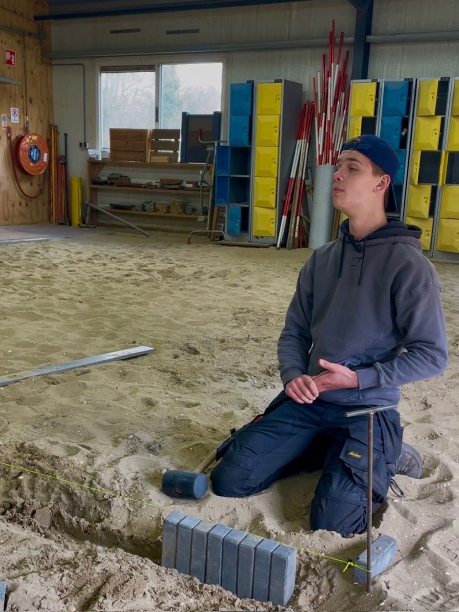 Een hoveniersstudent houdt lachend een vlag vast van Yuverta