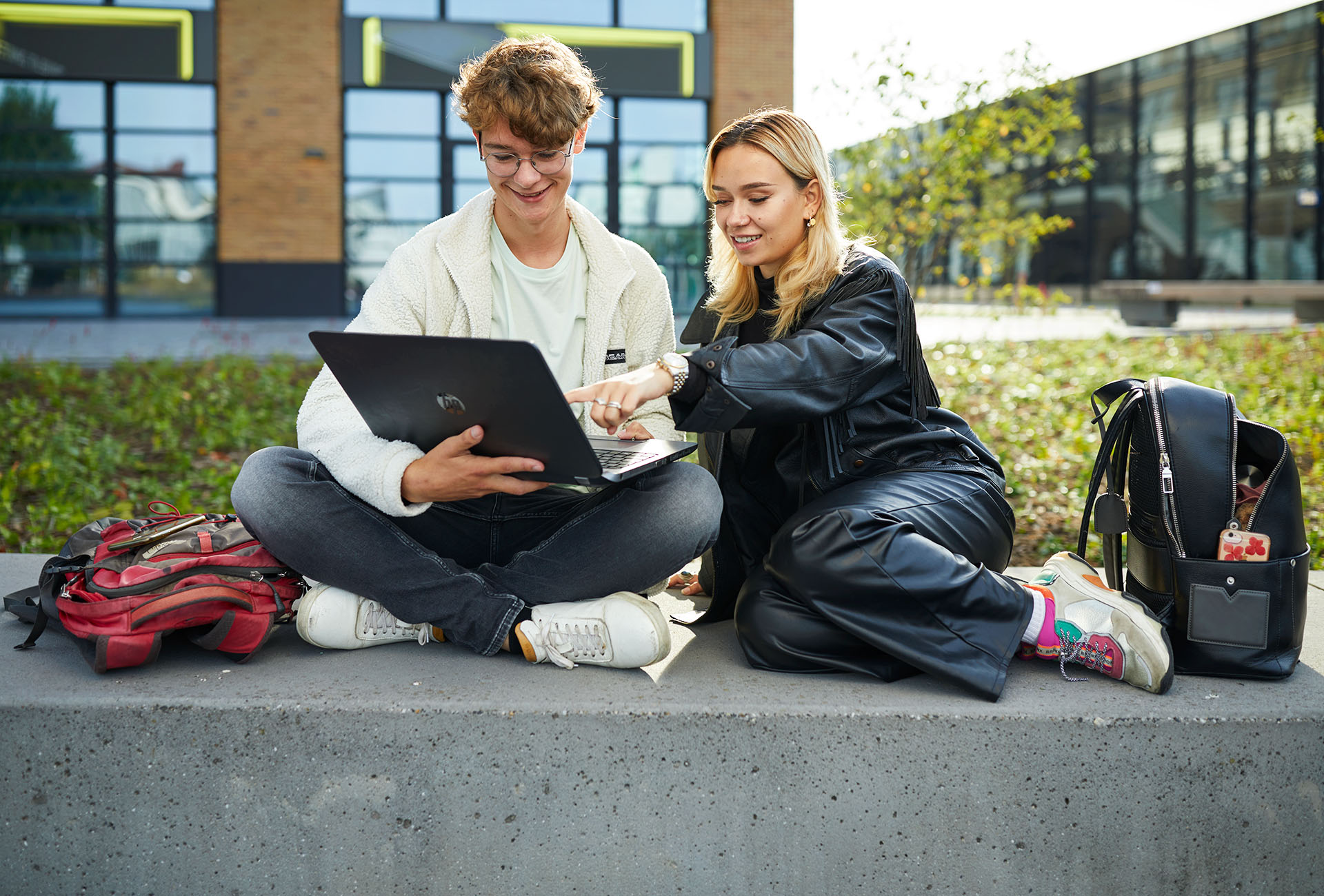 Twee studenten zitten samen buiten