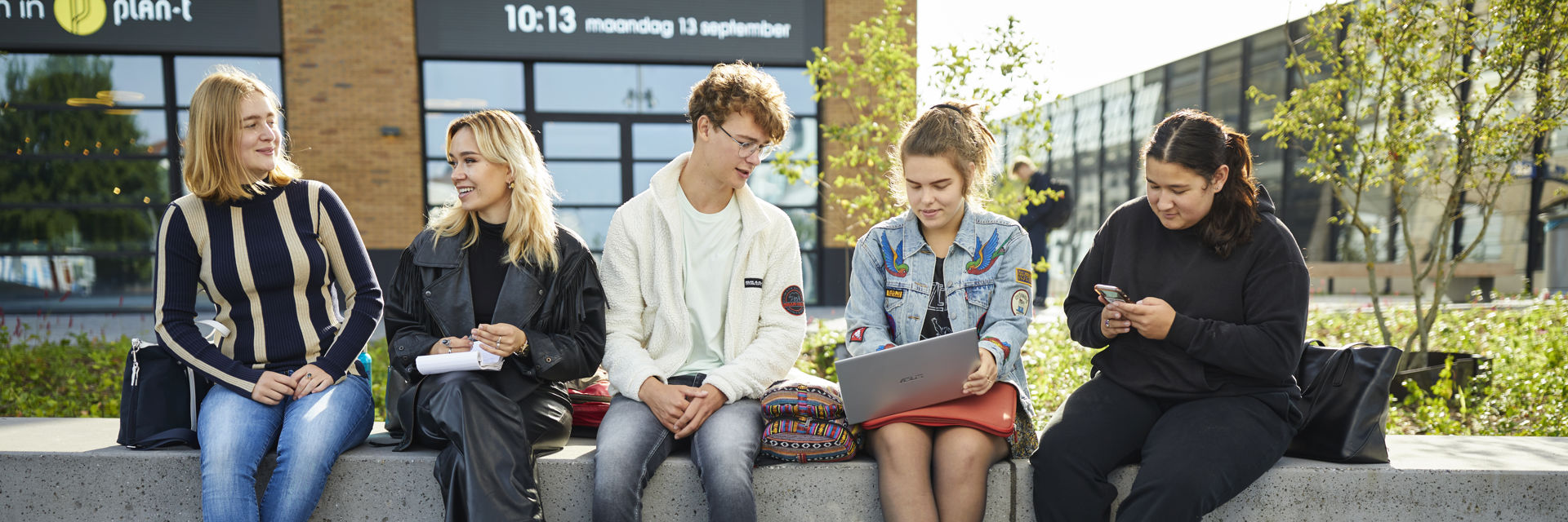 Een groep studenten zit samen buiten